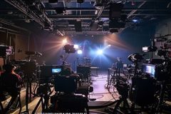 网红博主直播间幕后拍摄画面，多台摄像机环绕，工作人员忙碌布置场景